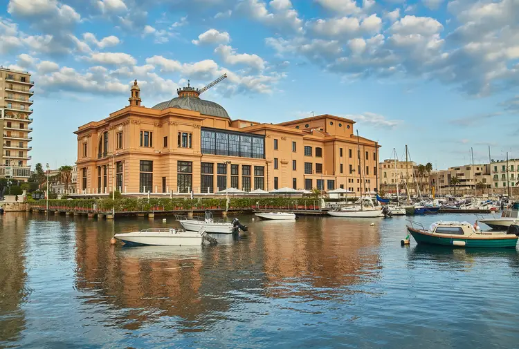 panoramica del famoso teatro margherita di bari, uno dei pochi teatri galleggianti in italia. sullo sfondo alcune barche ormeggiate.